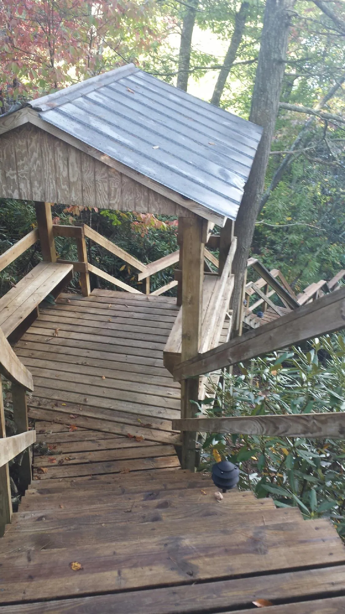 Metal roofed shelter over wooden steps on a wooded walkway — Skylight Repair & Installation work by our crew in Watervliet