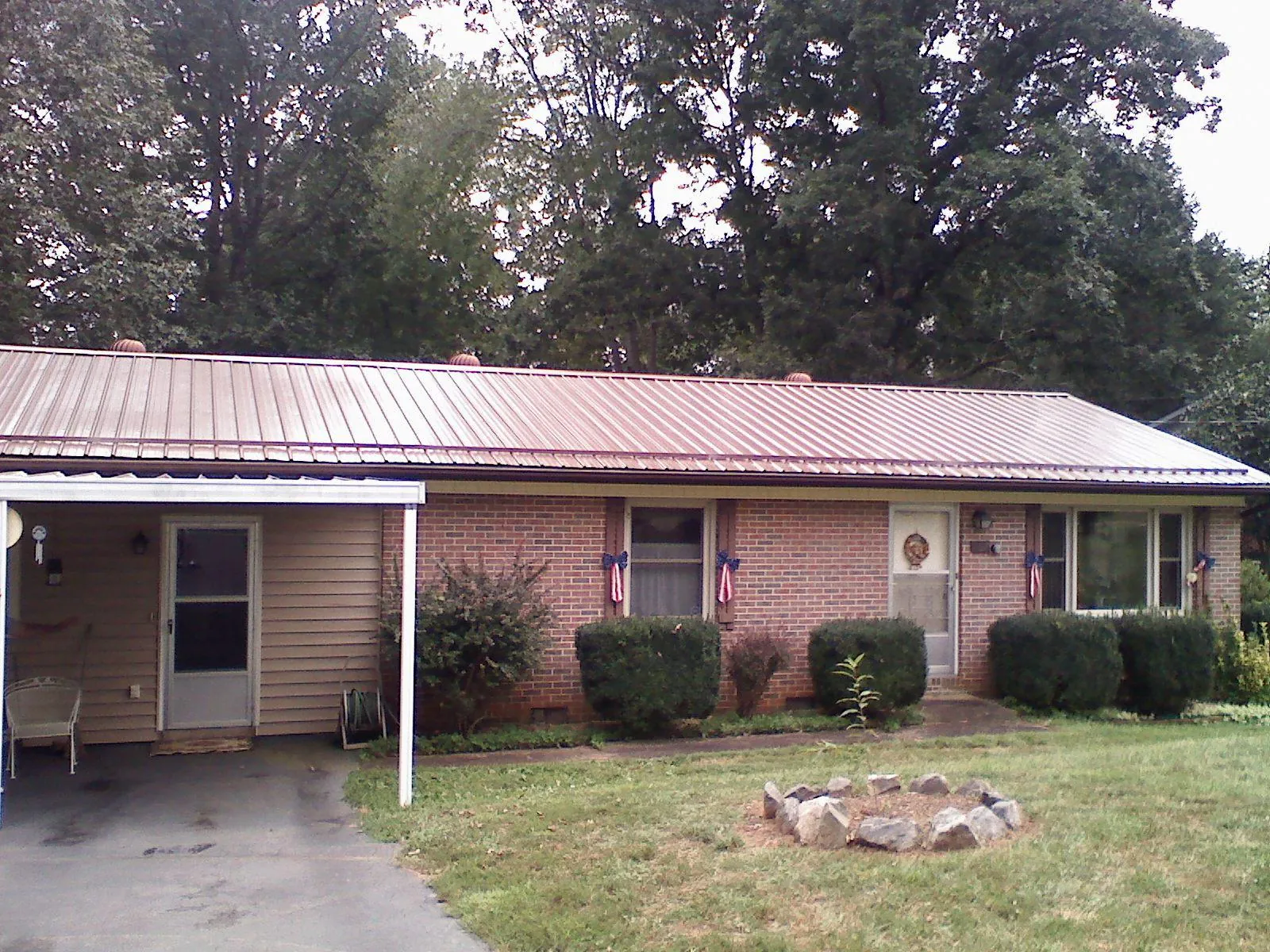Bronze metal roof and carport on a brick ranch home — Roof Repair work by our crew in Watervliet